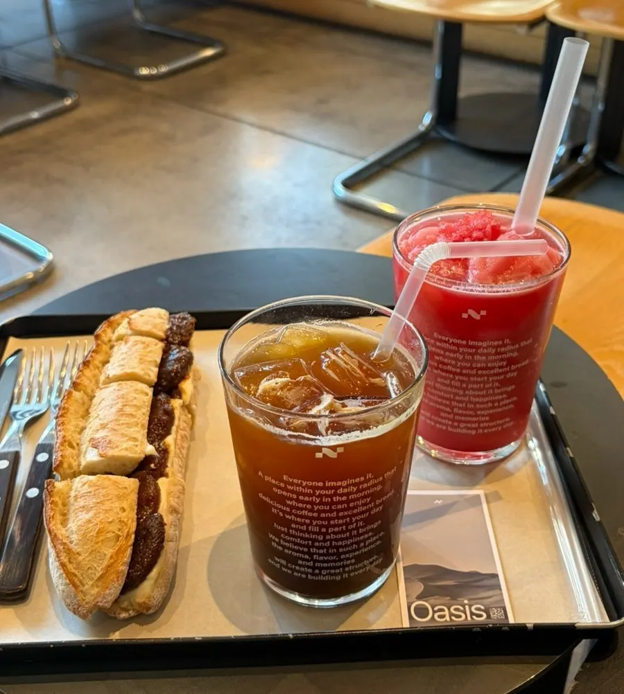 Order lineup of Americano, watermelon juice, and fig cream cheese baguette