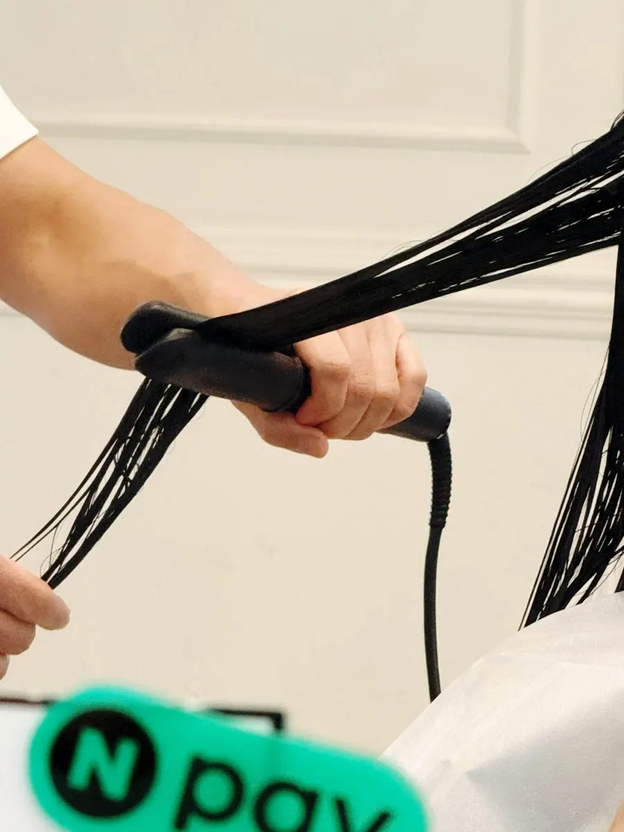 Combing through hair to evenly spread the clinic product