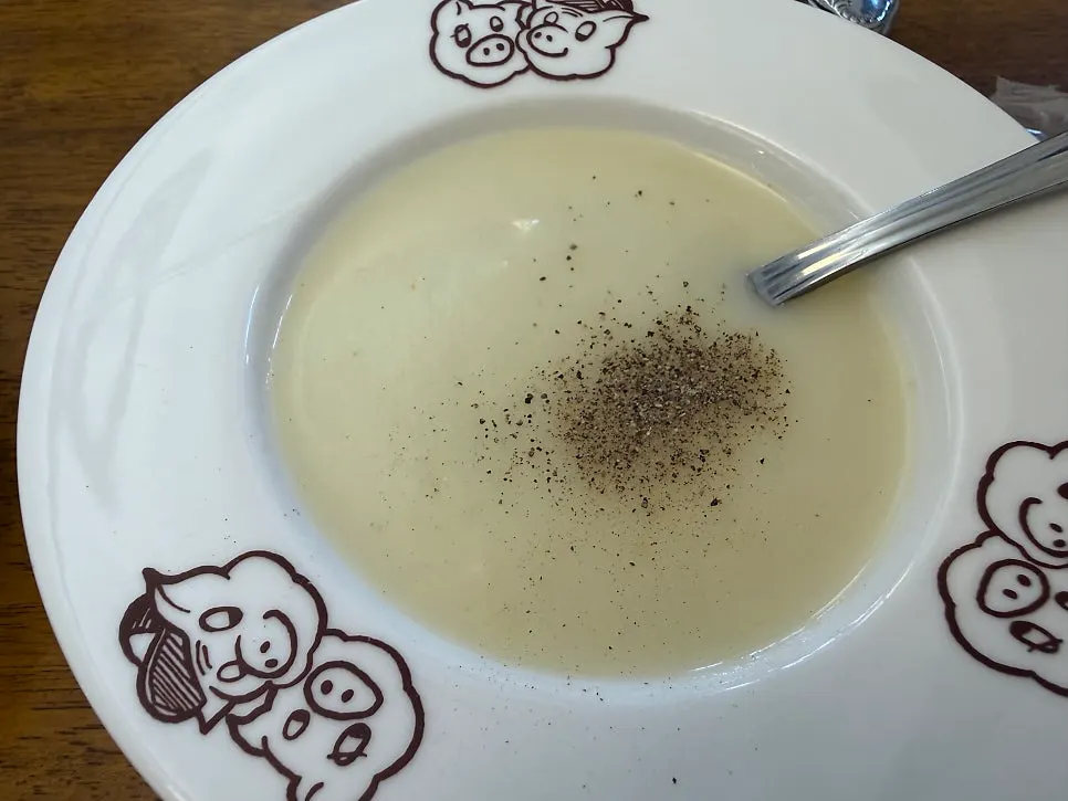 A bowl of soup with pepper added