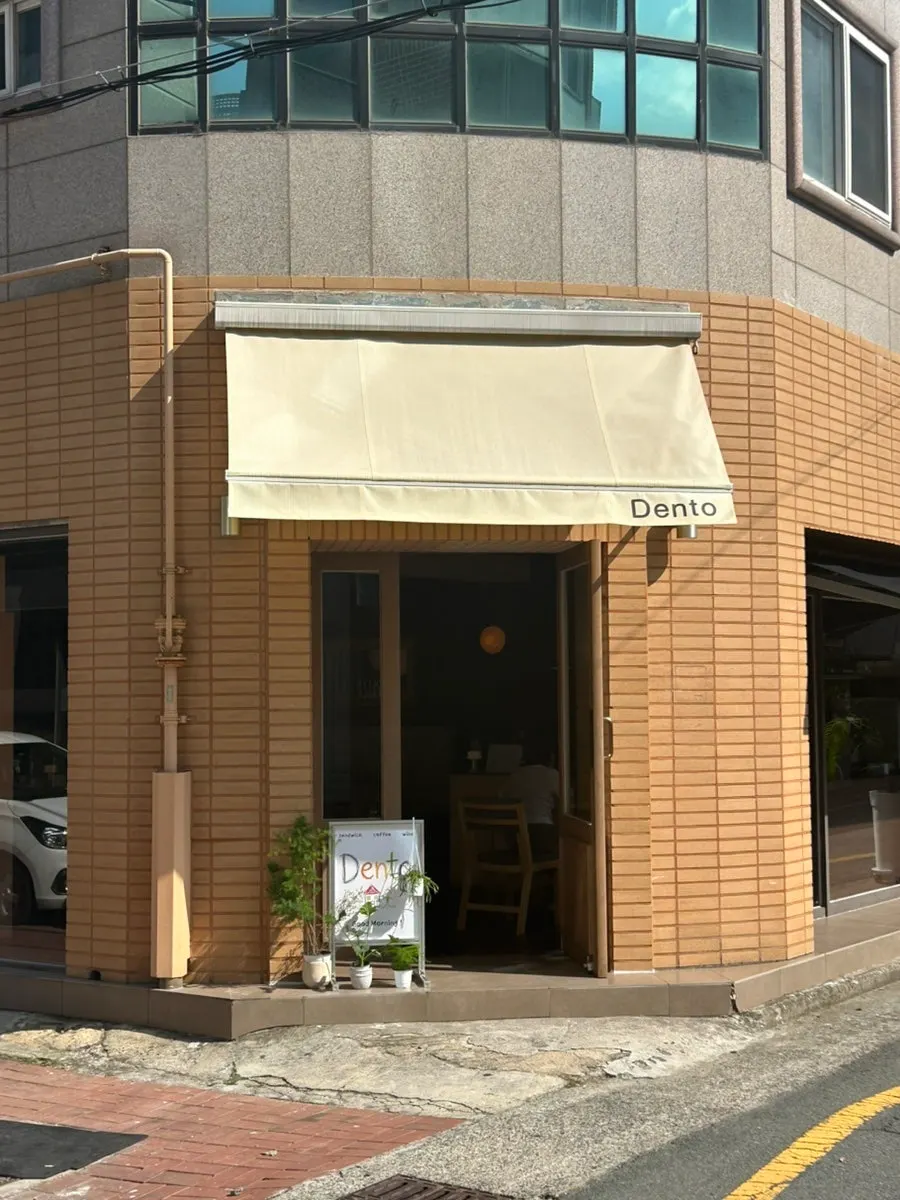 Dento's exterior with a colored-pencil-style standing sign