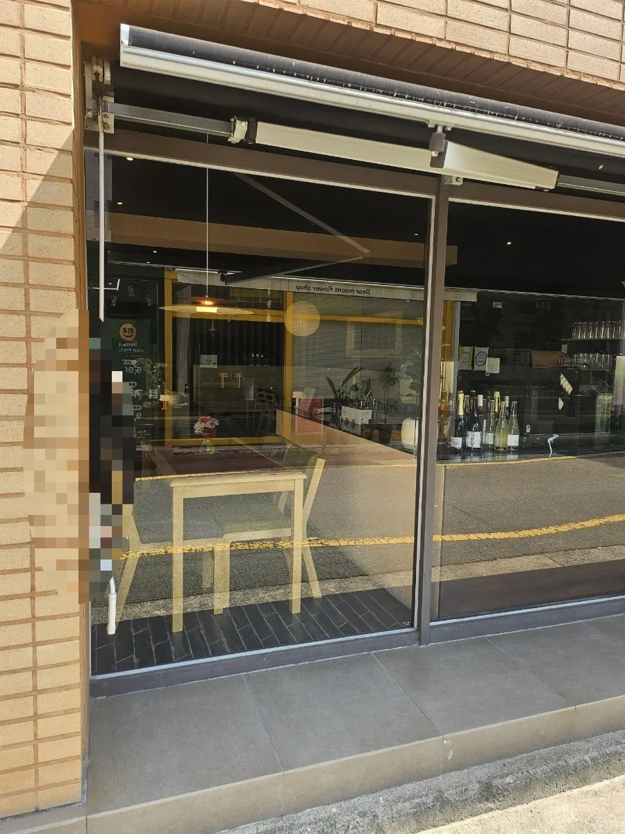 Dento's entrance with wood-toned interior and white awning