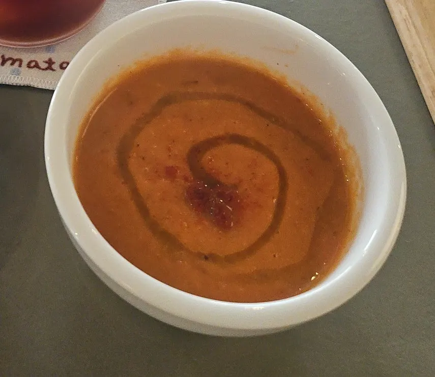 Tomato soup served alongside the bite-size sandwiches