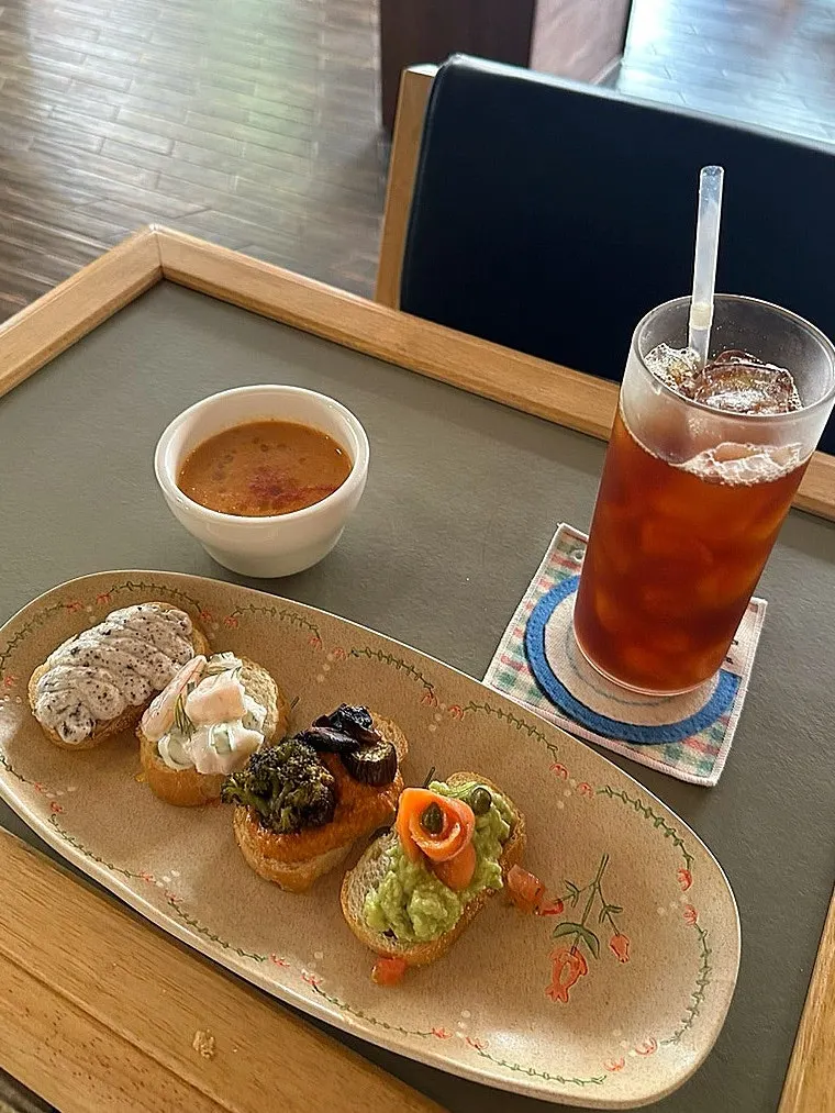 Brunch spread of bite-size sandwiches and tomato soup
