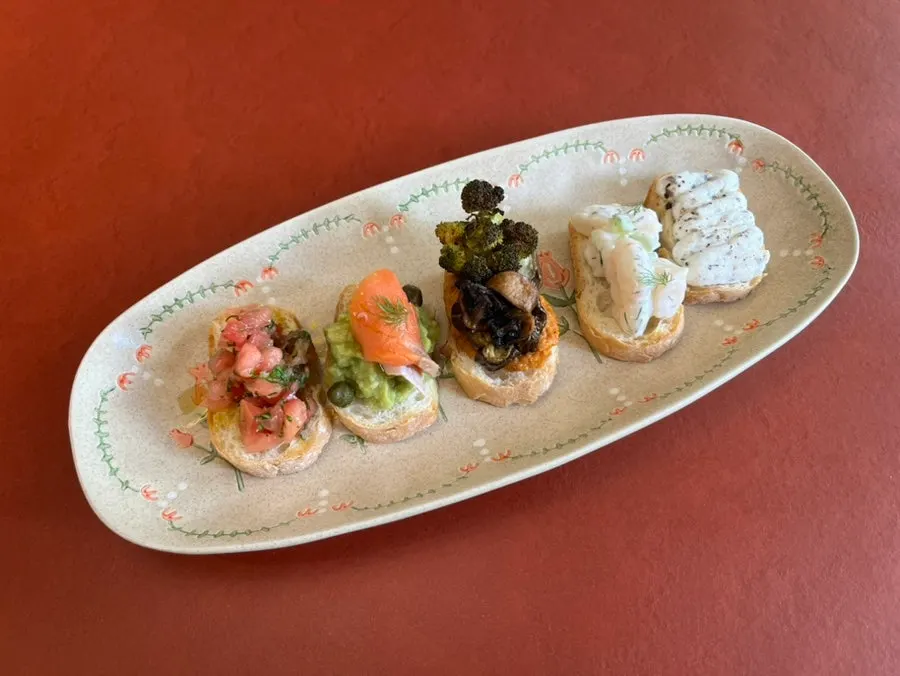 A plate with five one-bite open sandwiches