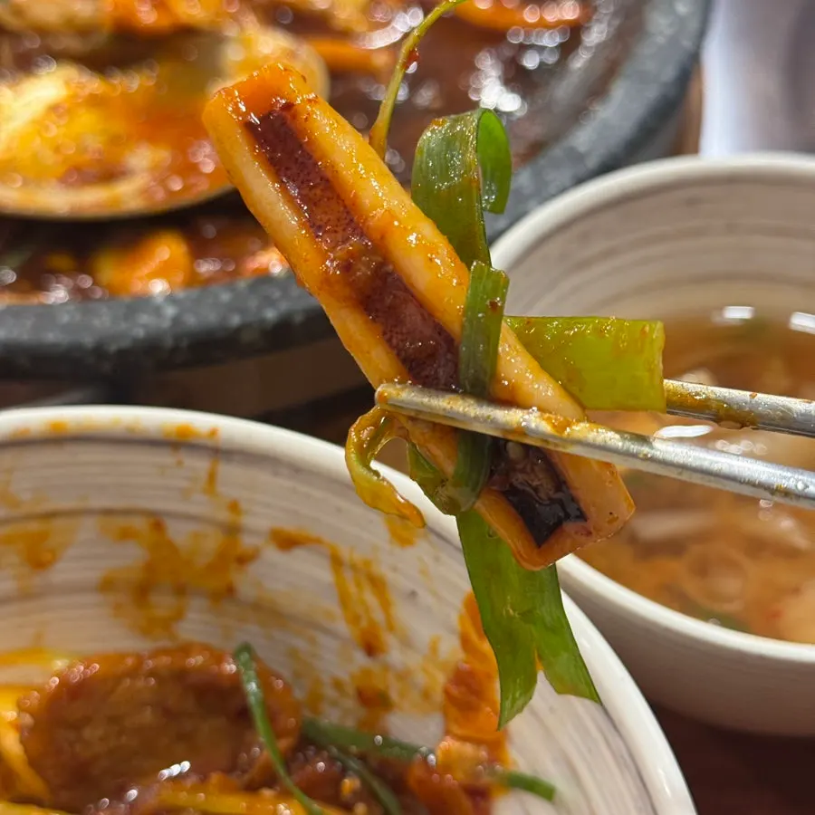 A bite of noodles fully soaked in the seasoning