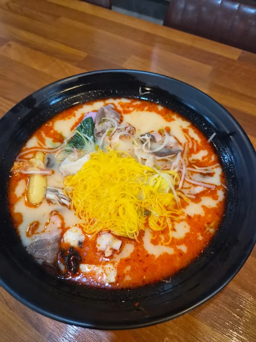 Mala tang topped with corn noodles and beef
