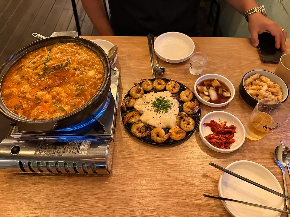 Table spread with hot pot and shrimp stir-fry together