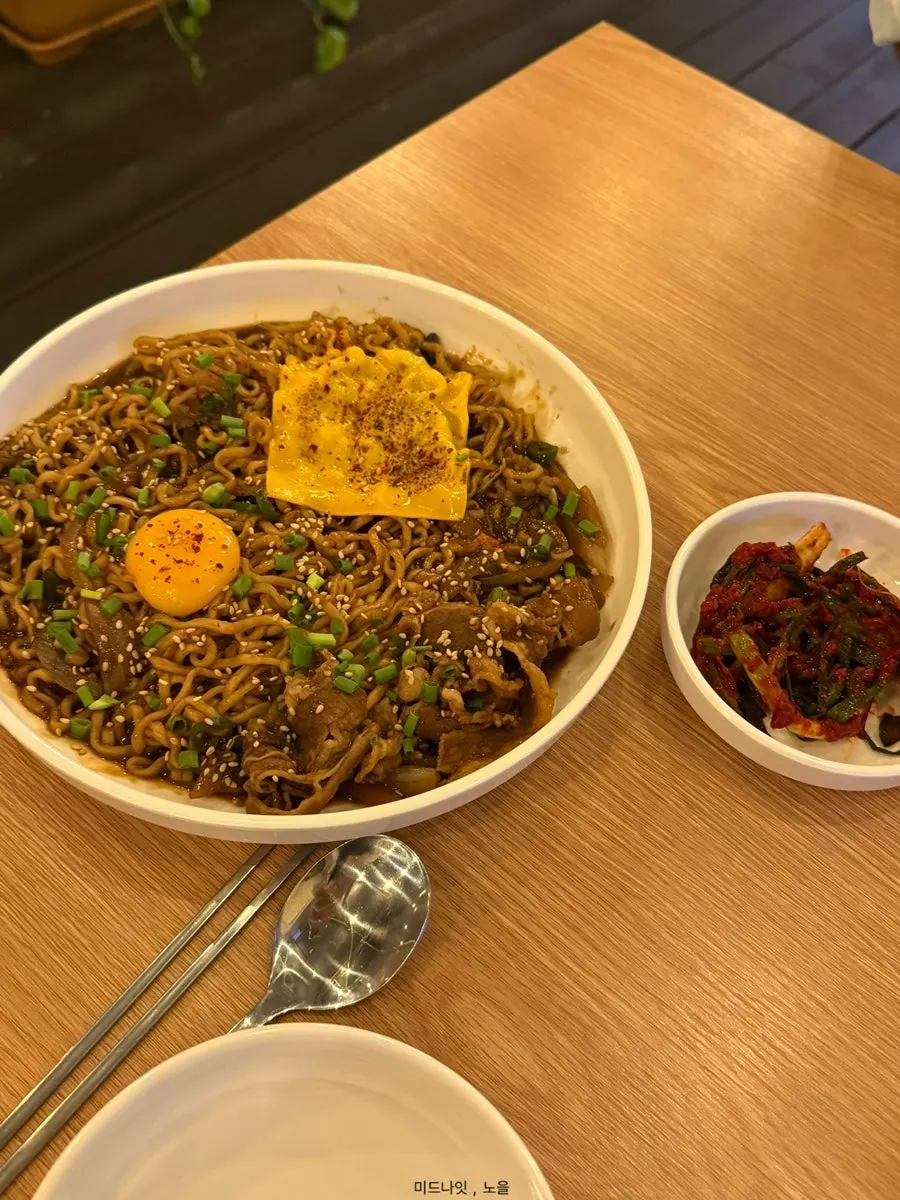 Jansang's jjagyechi topped with egg yolk and cheese