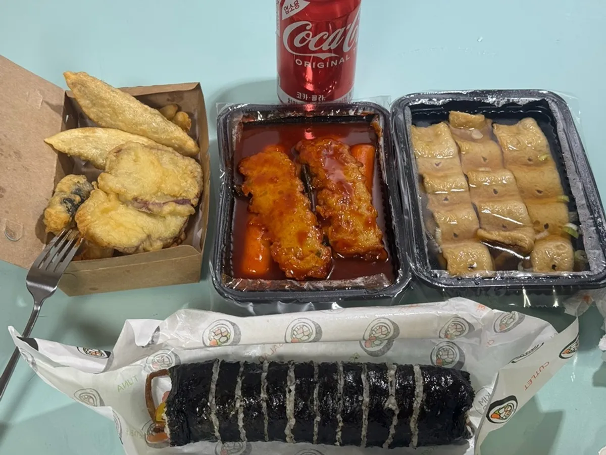Set Menu A packed to go with tteokbokki, fish cake, gimbap, and fried snacks