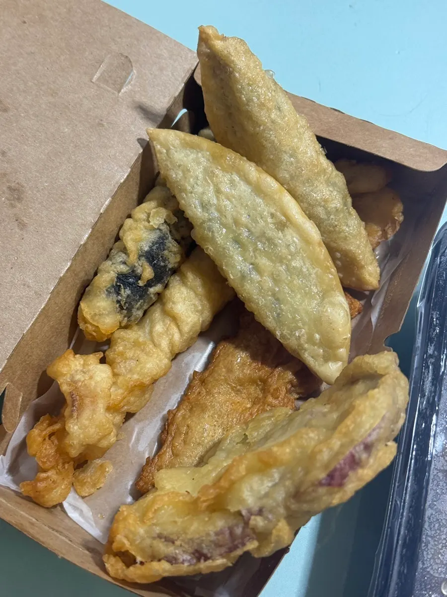 A piece of fish cake picked up with chopsticks