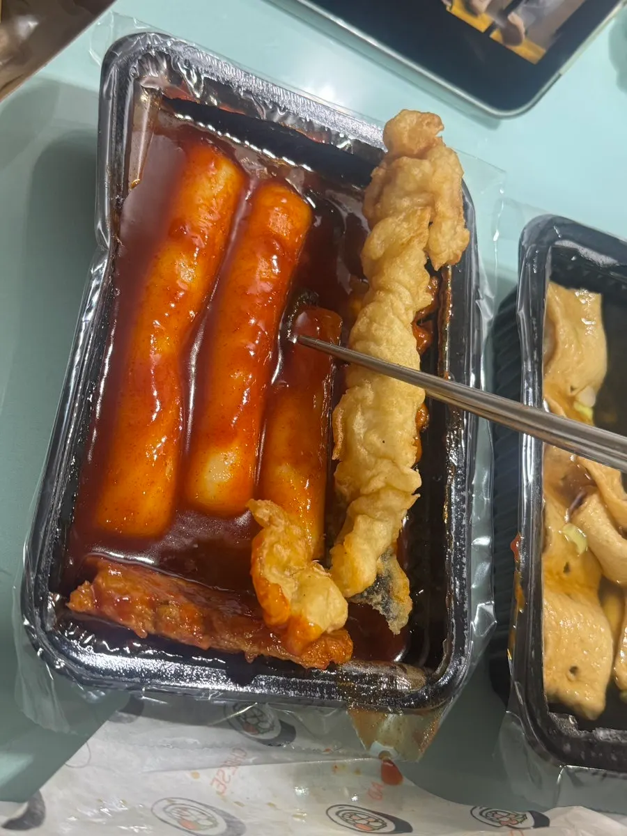 Fish cake takeout container submerged in broth