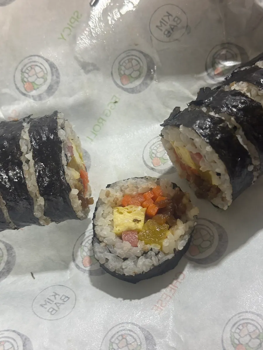 Gimbap dipped into tteokbokki sauce