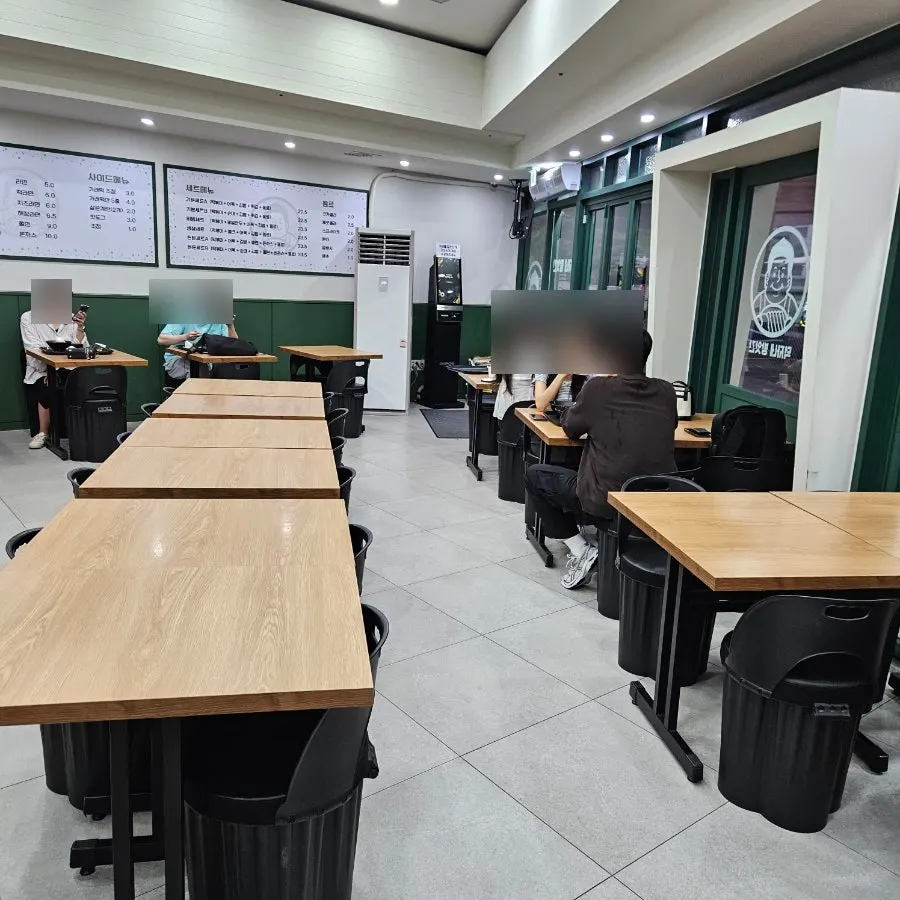 Dining hall with green walls and wooden tables at Deokjane Bangatgan