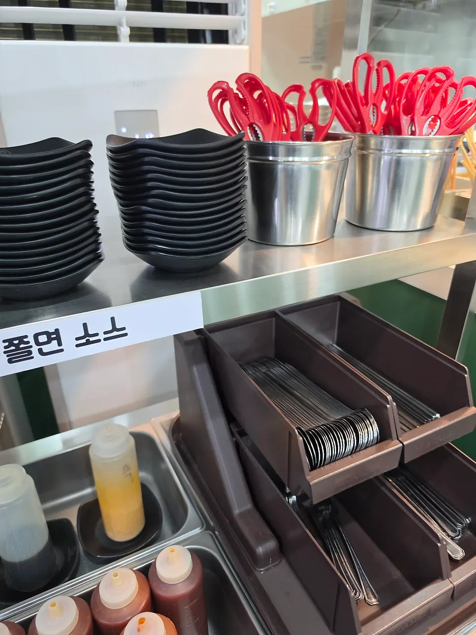 Self-bar drawer with plates, red cutting scissors, and utensils