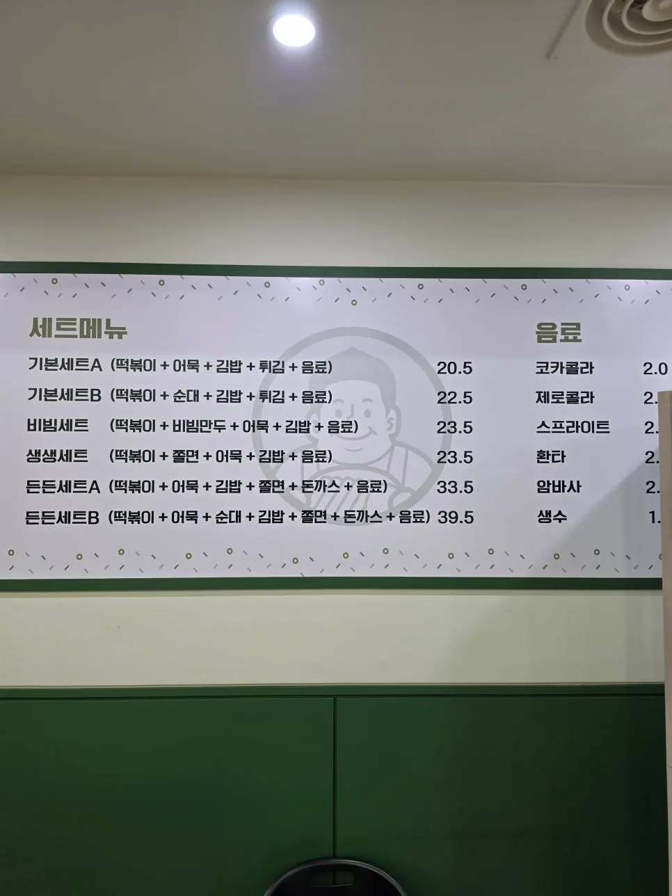 Deokjane Bangatgan's menu board listing tteokbokki, fried snacks, and gimbap