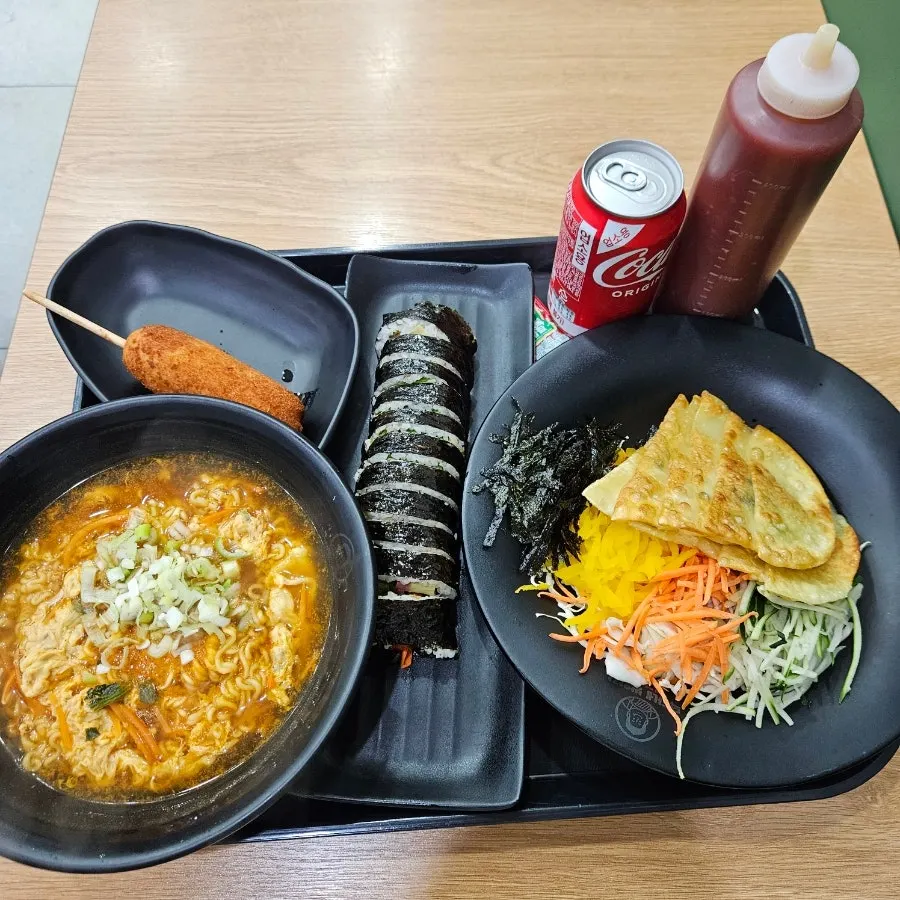 A table spread with garaetteok tteokbokki, ramyeon, and gimbap