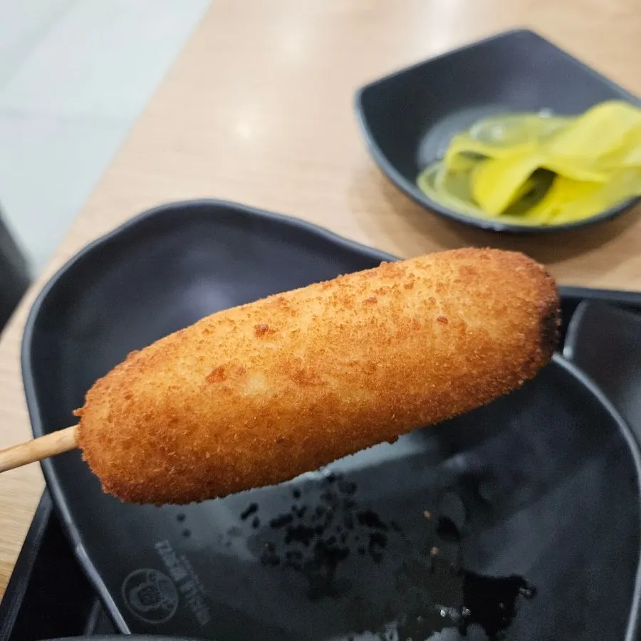A golden-brown hot dog on a plate