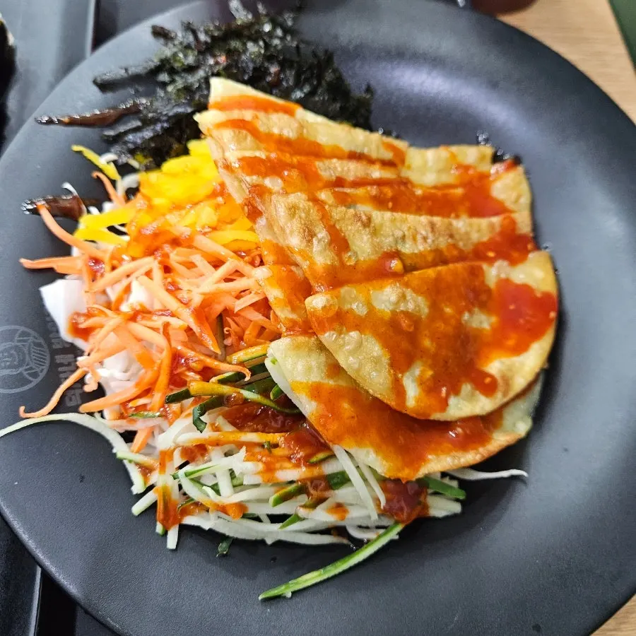Bibim mandu drizzled with spicy sauce