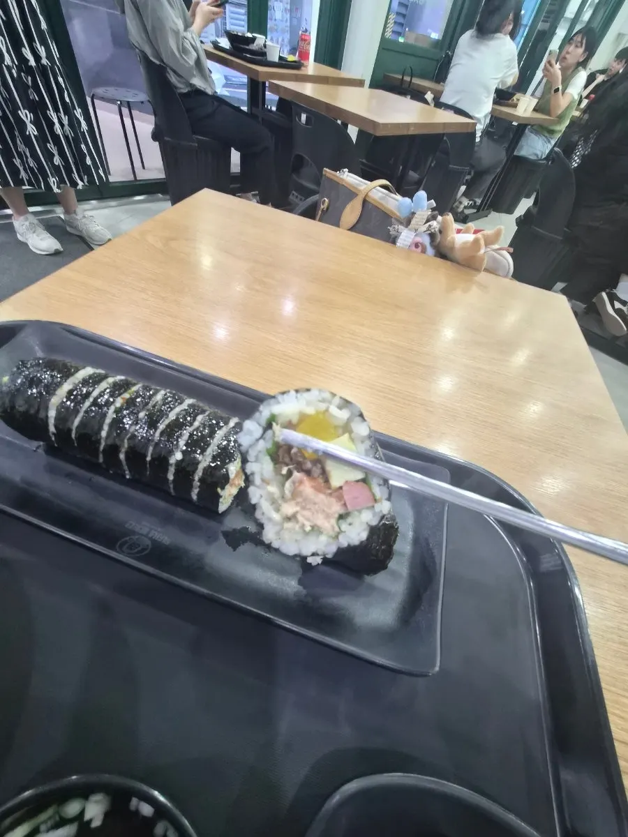 Tuna gimbap dipped into tteokbokki sauce