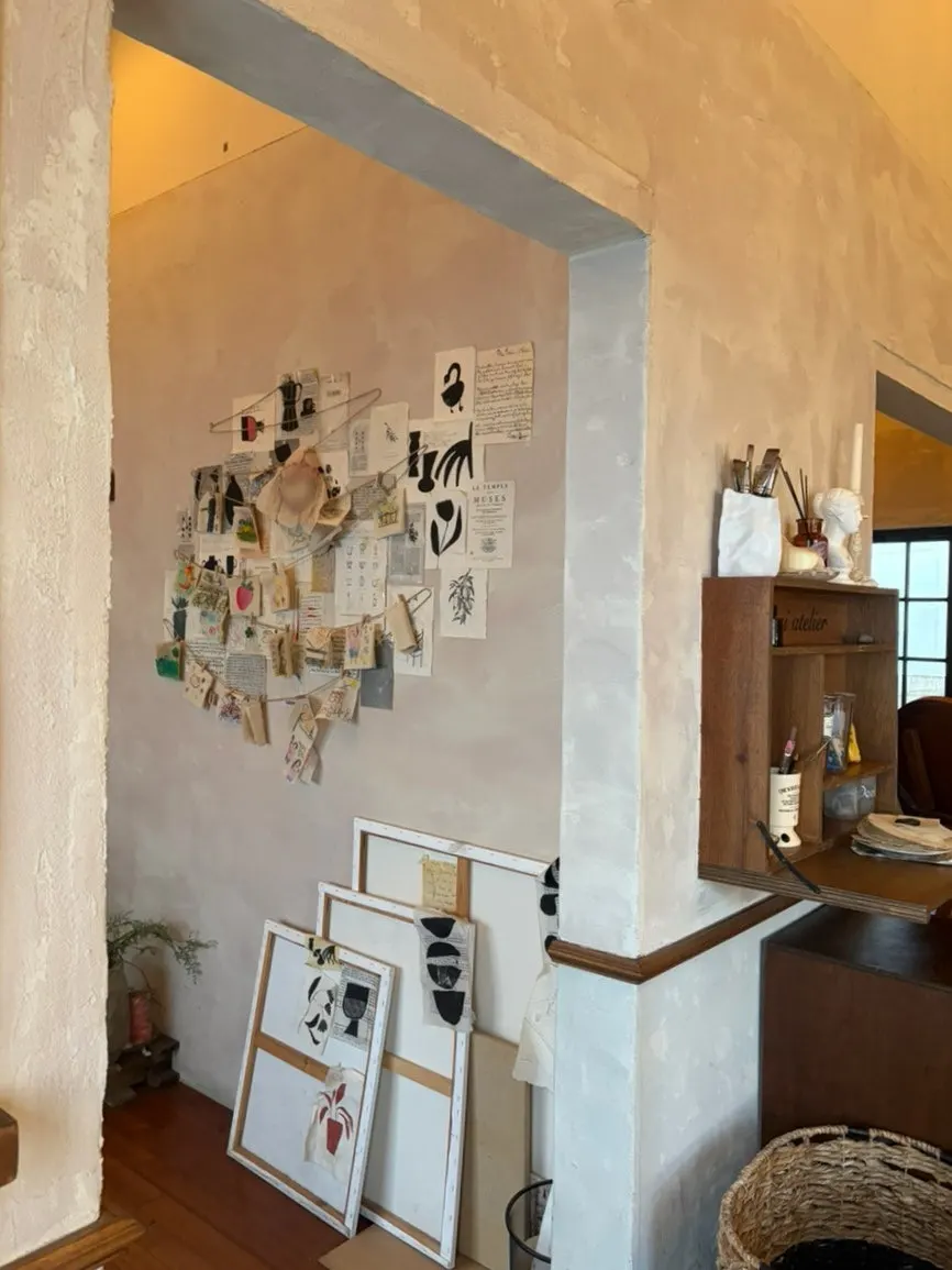 Café wall decorated with postcards and drawings