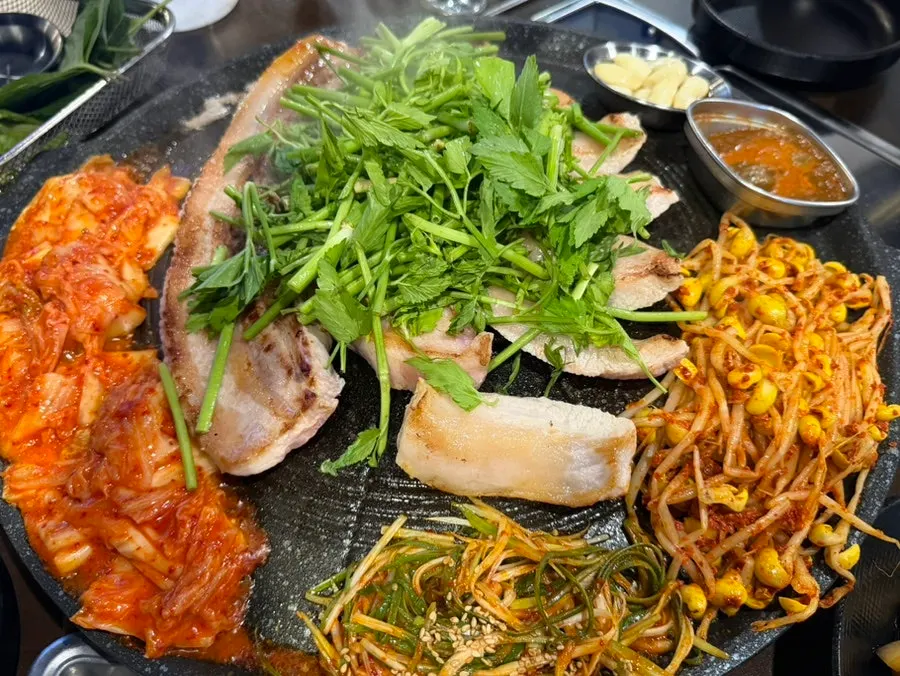 Kimchi and bean sprouts grilling alongside the meat on the cauldron lid