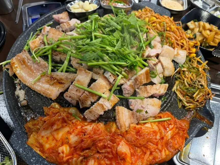 Side dishes grilled together in the rendered fat on the cauldron lid