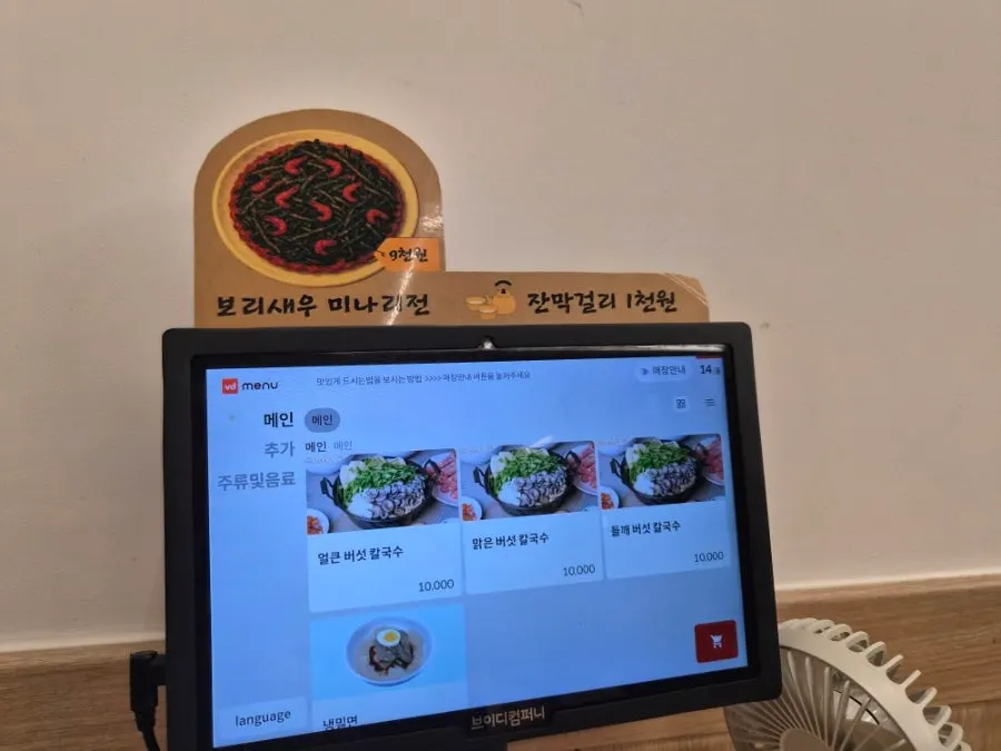 Kiosk menu screen showing photos and prices