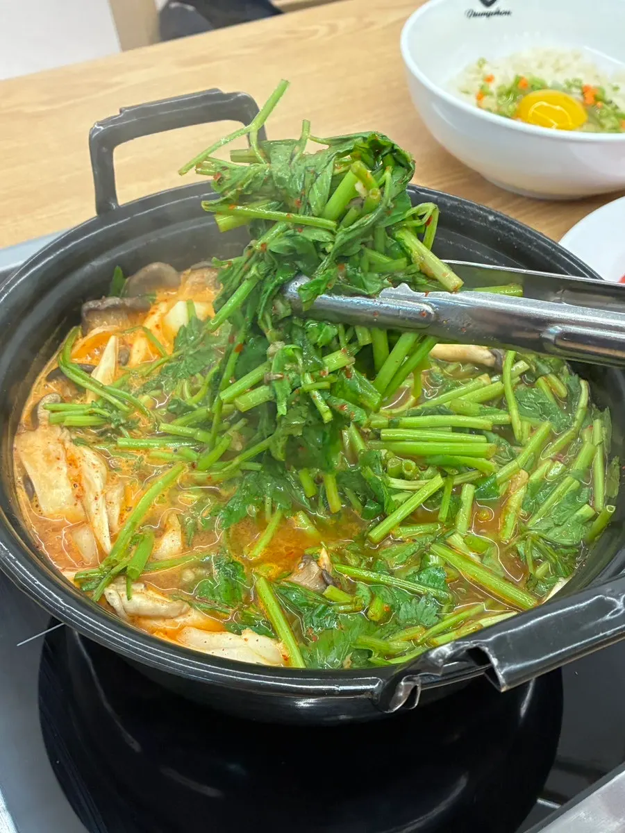 Pot of mushroom shabu-shabu simmering with vegetables