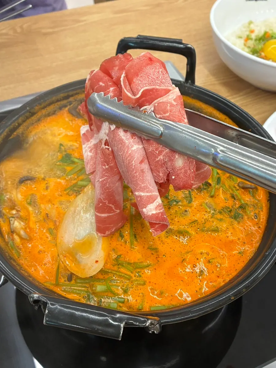 Cooked vegetables and beef scooped into a bowl