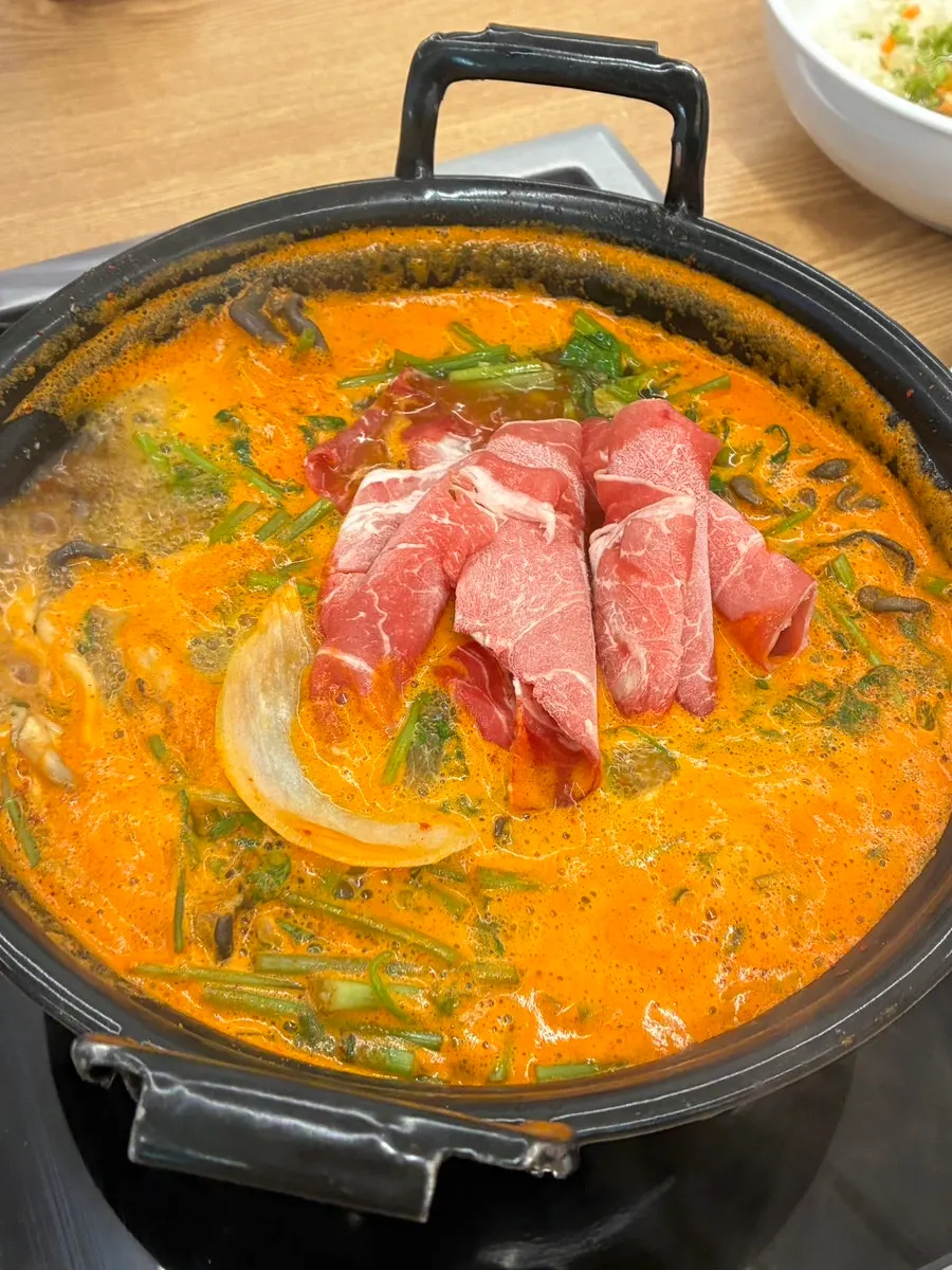 Bowl of kalguksu topped with meat and mushrooms