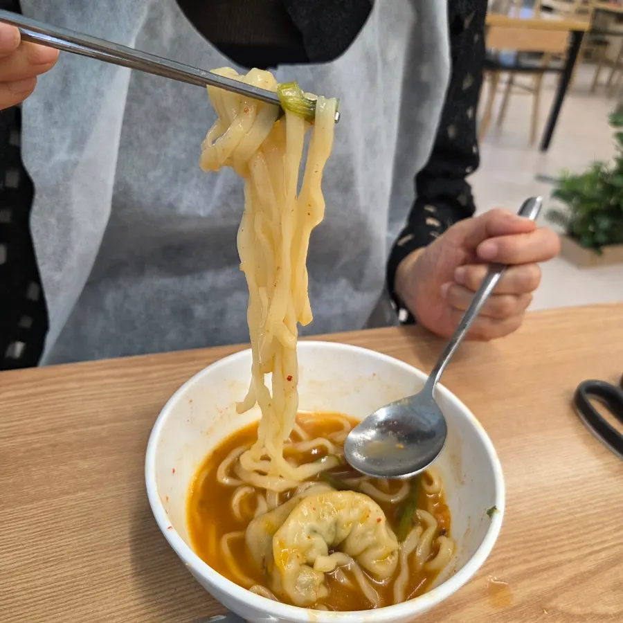 Kalguksu noodles simmering in the spicy broth