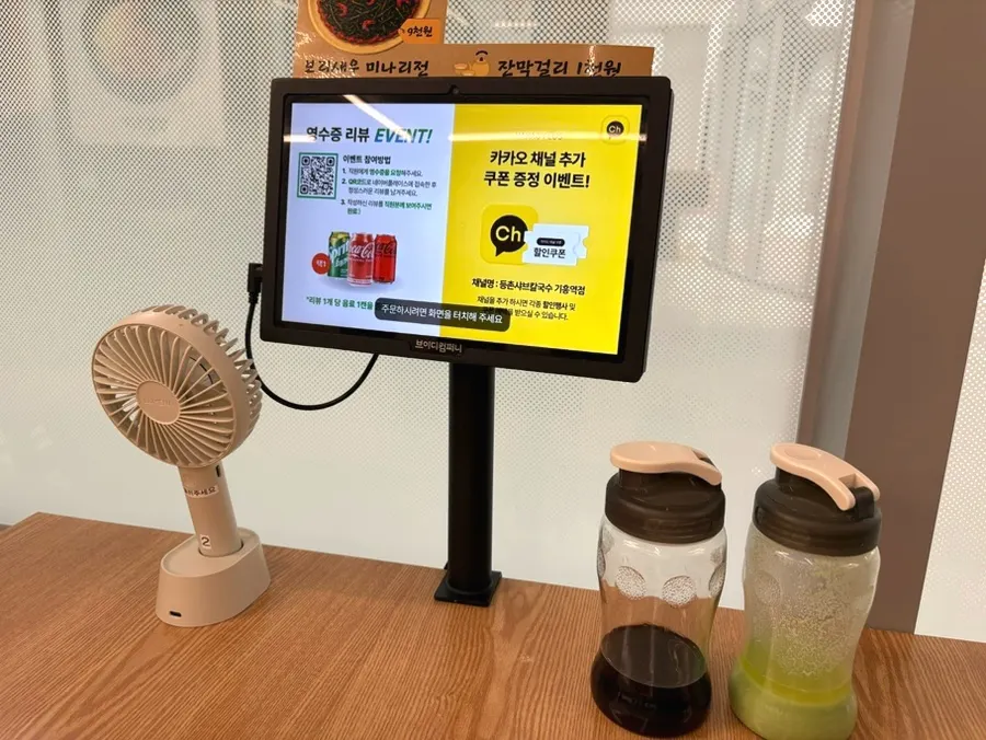 Store kiosk and handheld fan placed on the table