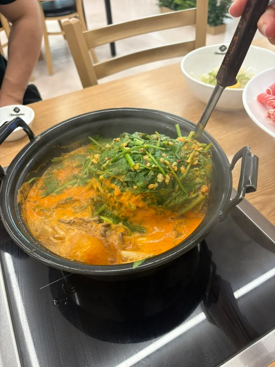 끓는 육수에 미나리를 넣는 모습