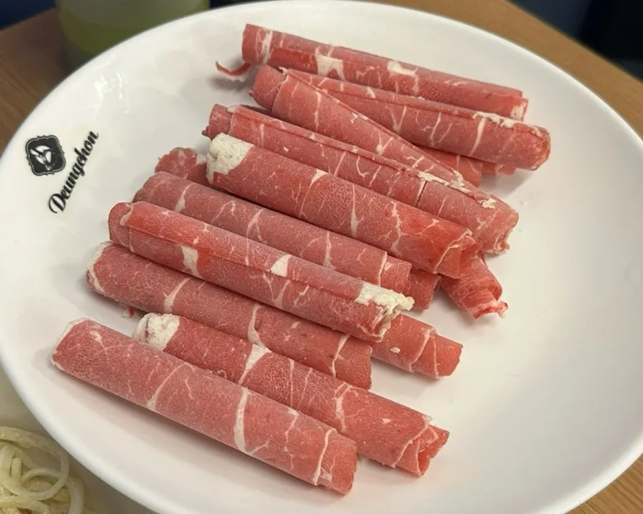 Plate of cooked beef and minari lifted out of the pot