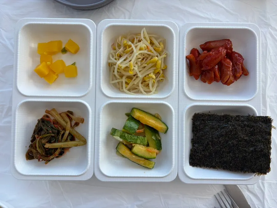 A spread of banchan including pickled radish and seasoned bean sprouts