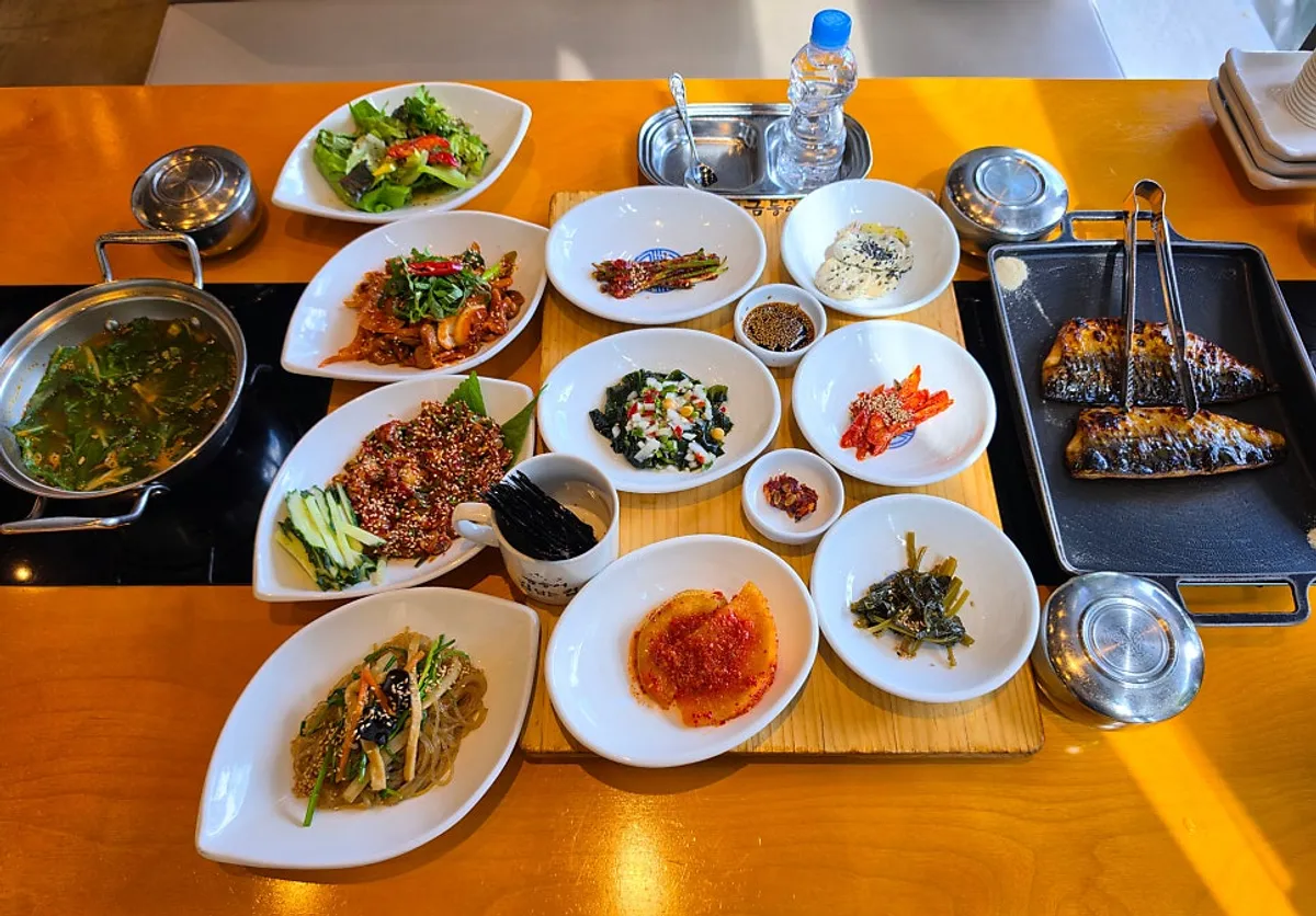 Wood-fired grilled mackerel, spicy pork stir-fry, and cockle salad spread