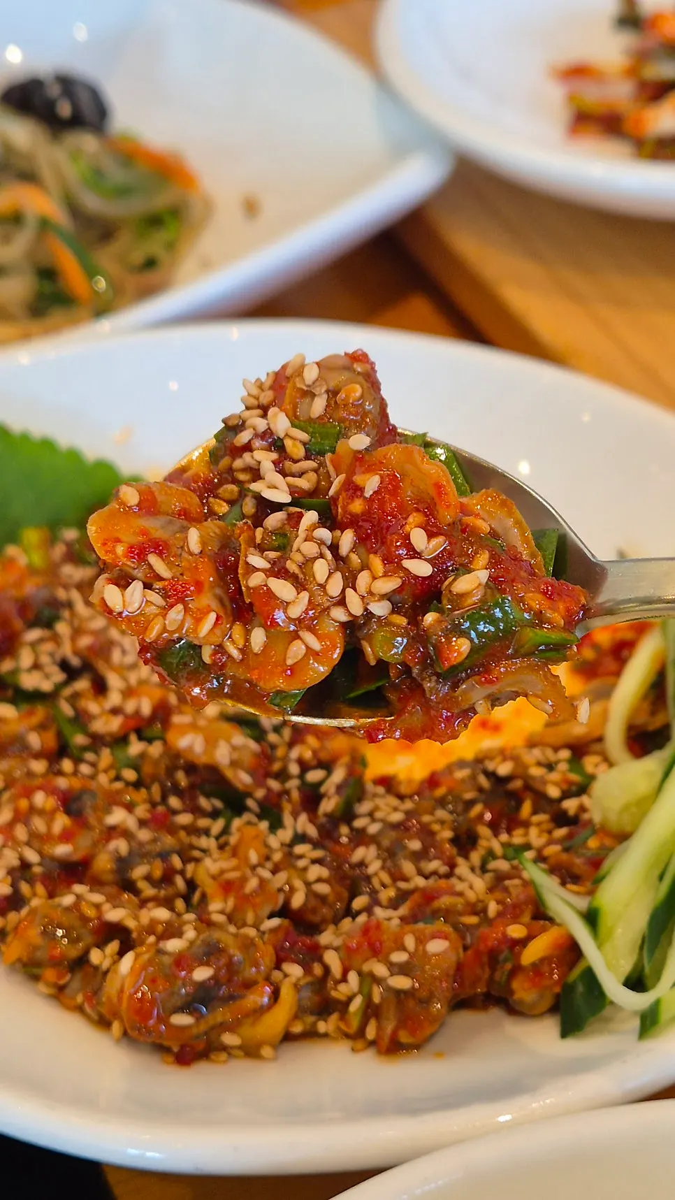 A bite of mackerel gim wrap topped with seed jeotgal