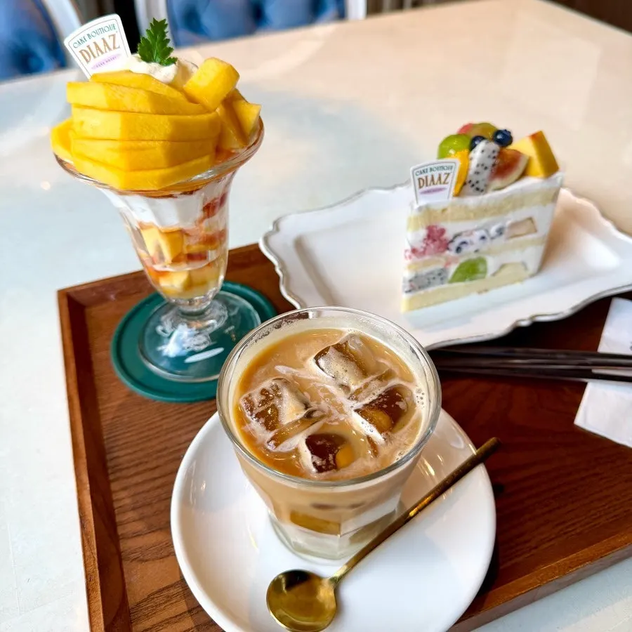Table setting with peach parfait, flat white, and fruit cake