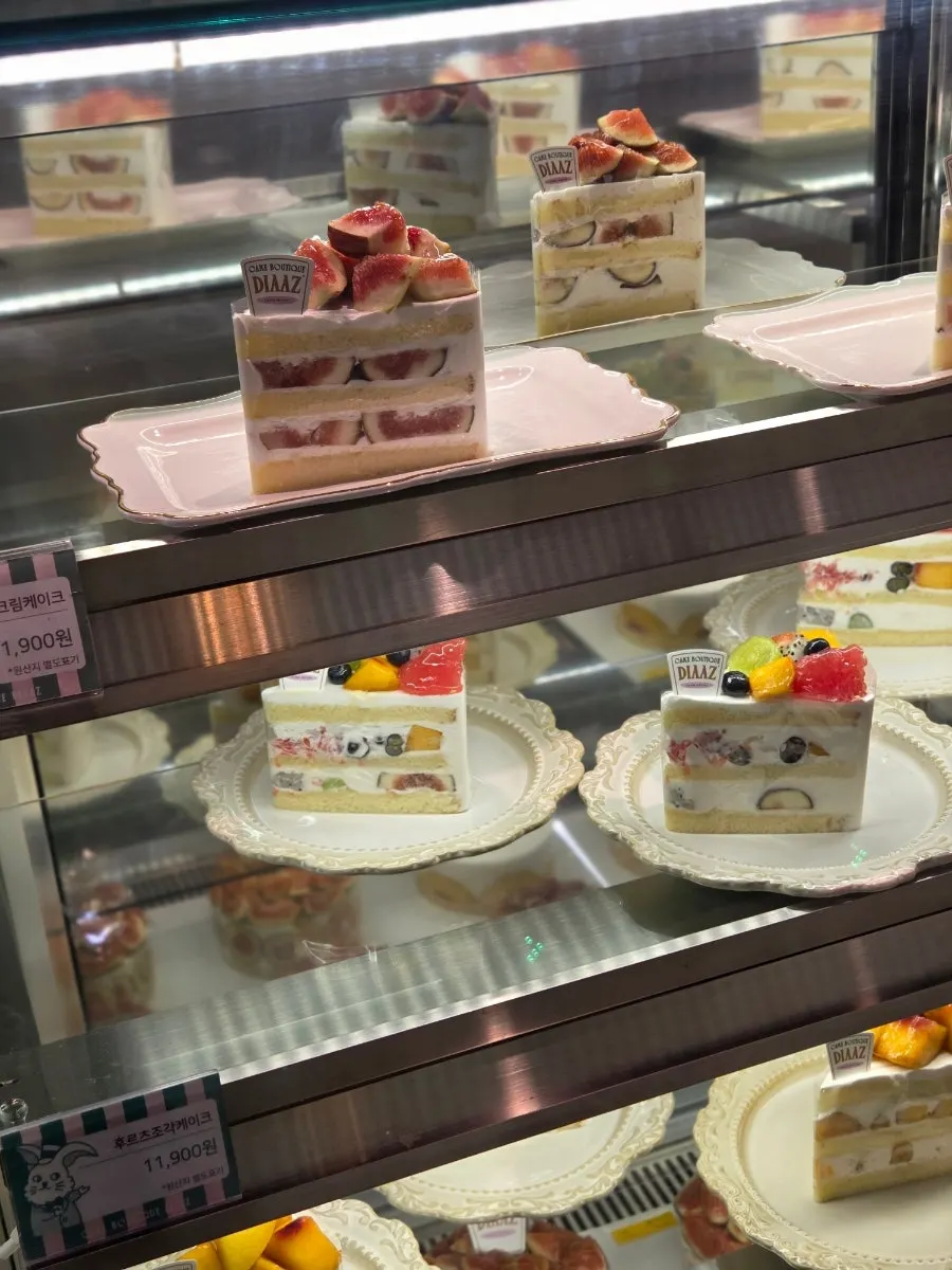 Display case packed with fresh cream cakes