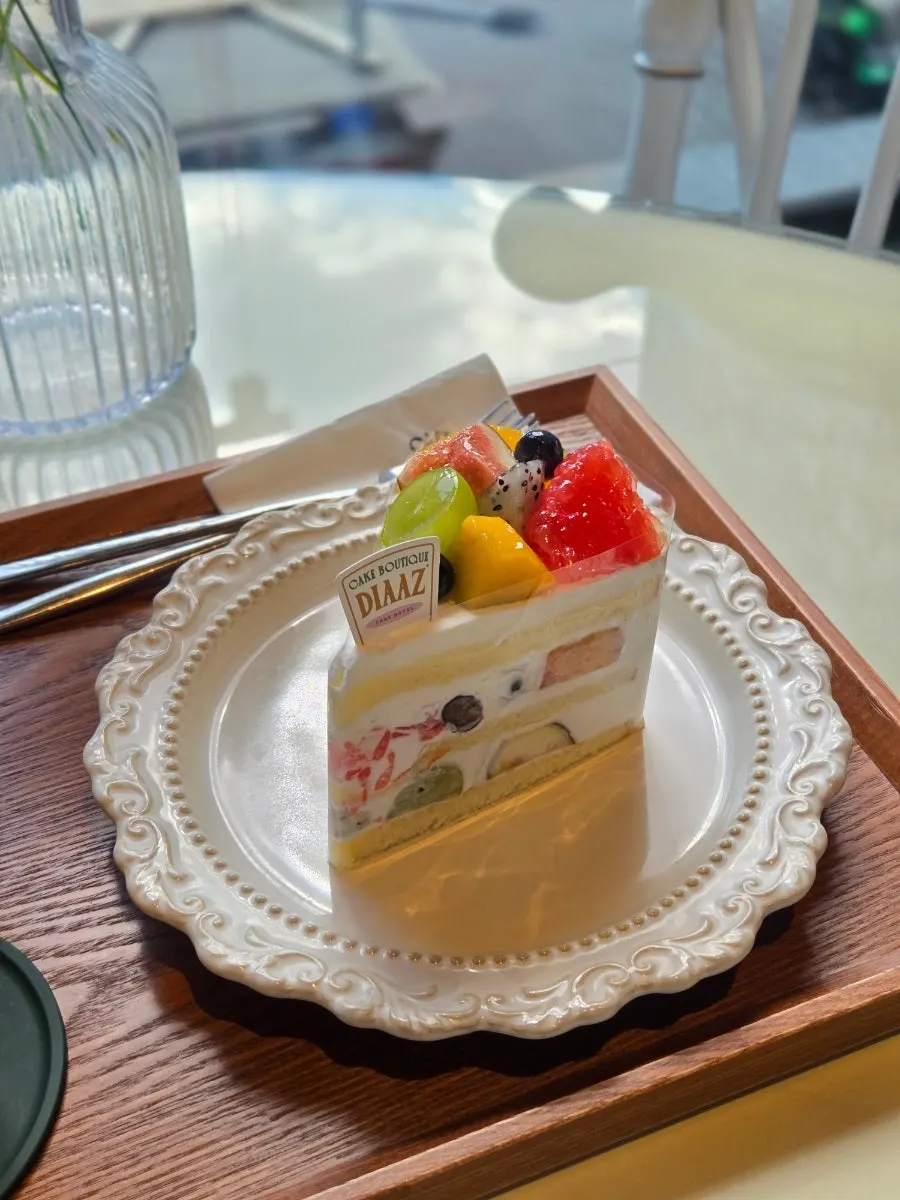 A slice of fruit cream cake filled with fresh fruit