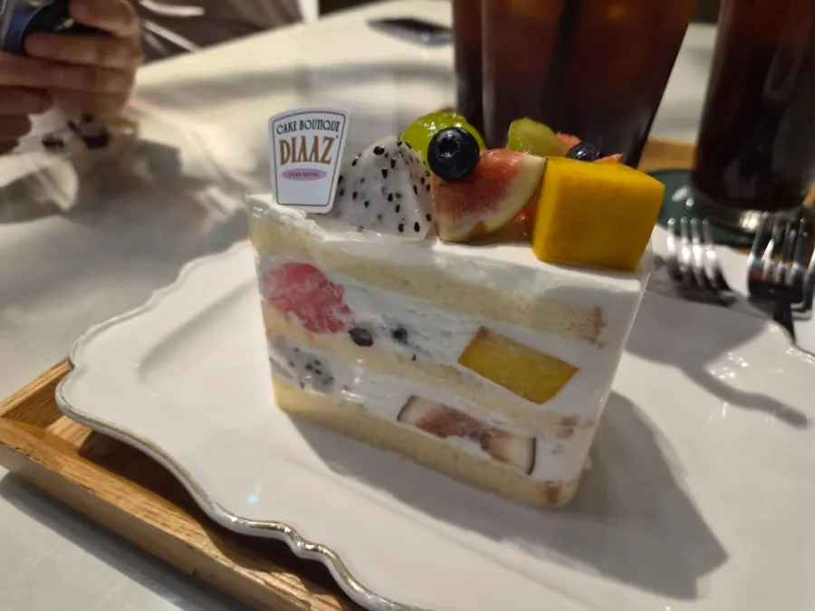 Closing shot of the fruit fresh cream cake with iced americano