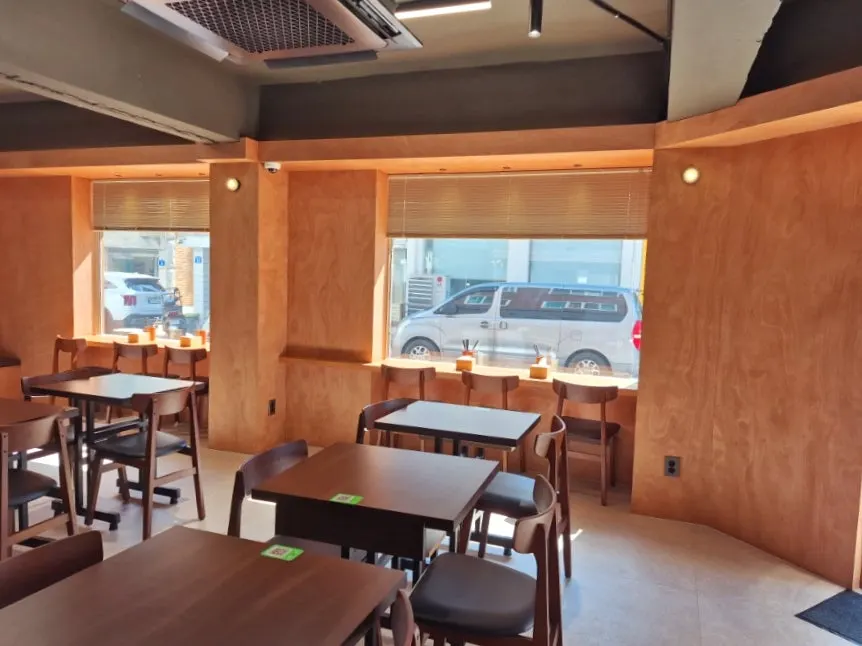 Dining hall seating with group tables at Dimideun Gunja