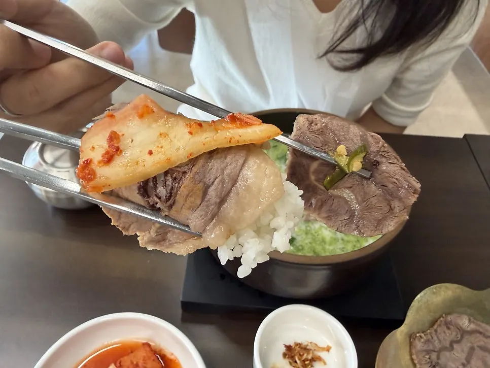 A spoonful of boiled pork topped with kkakdugi