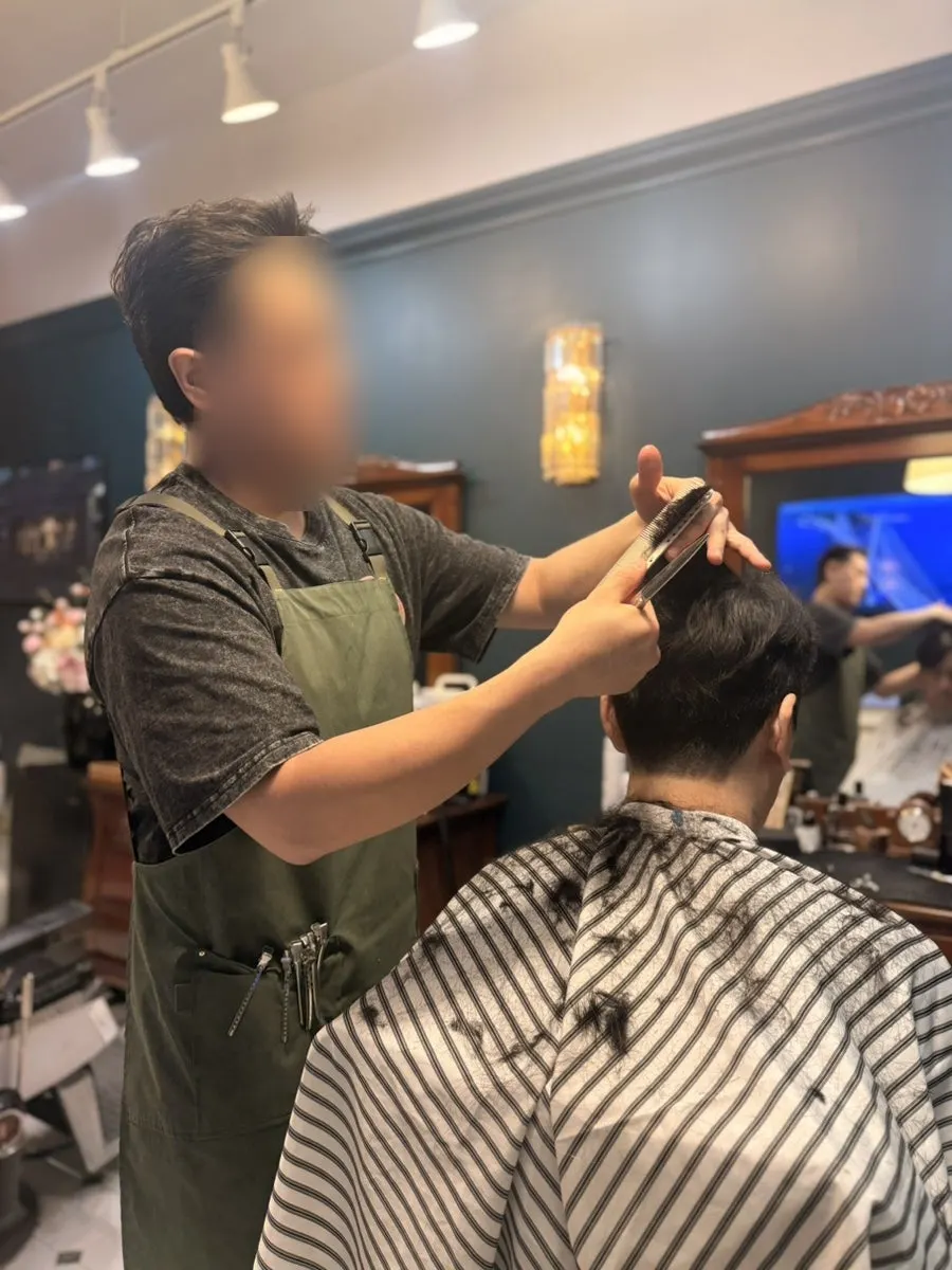 Barber cutting men's hair