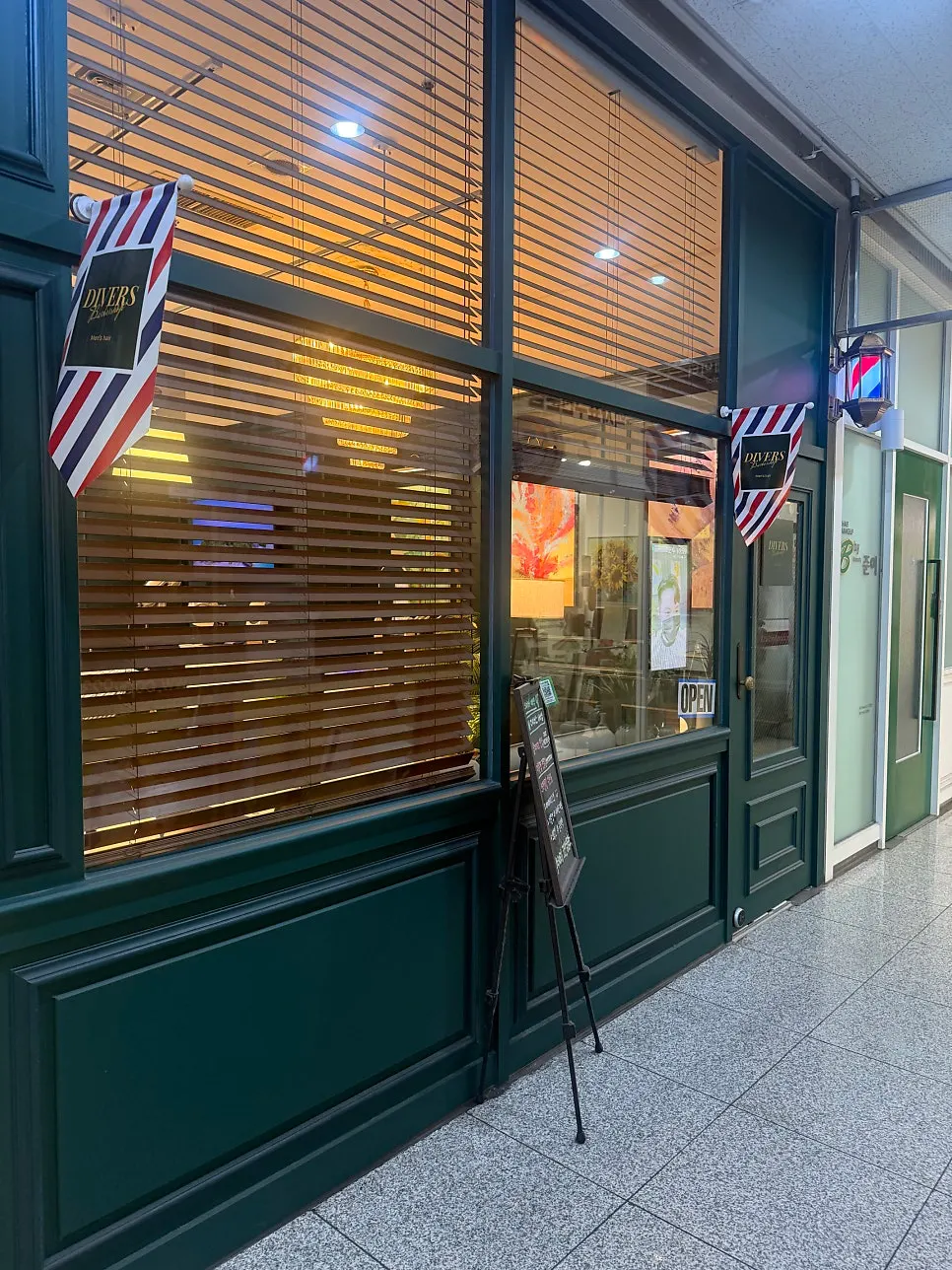 Green storefront of Divers Barbershop in the basement of SK Herb Blue near Gangnam-gu Office Station