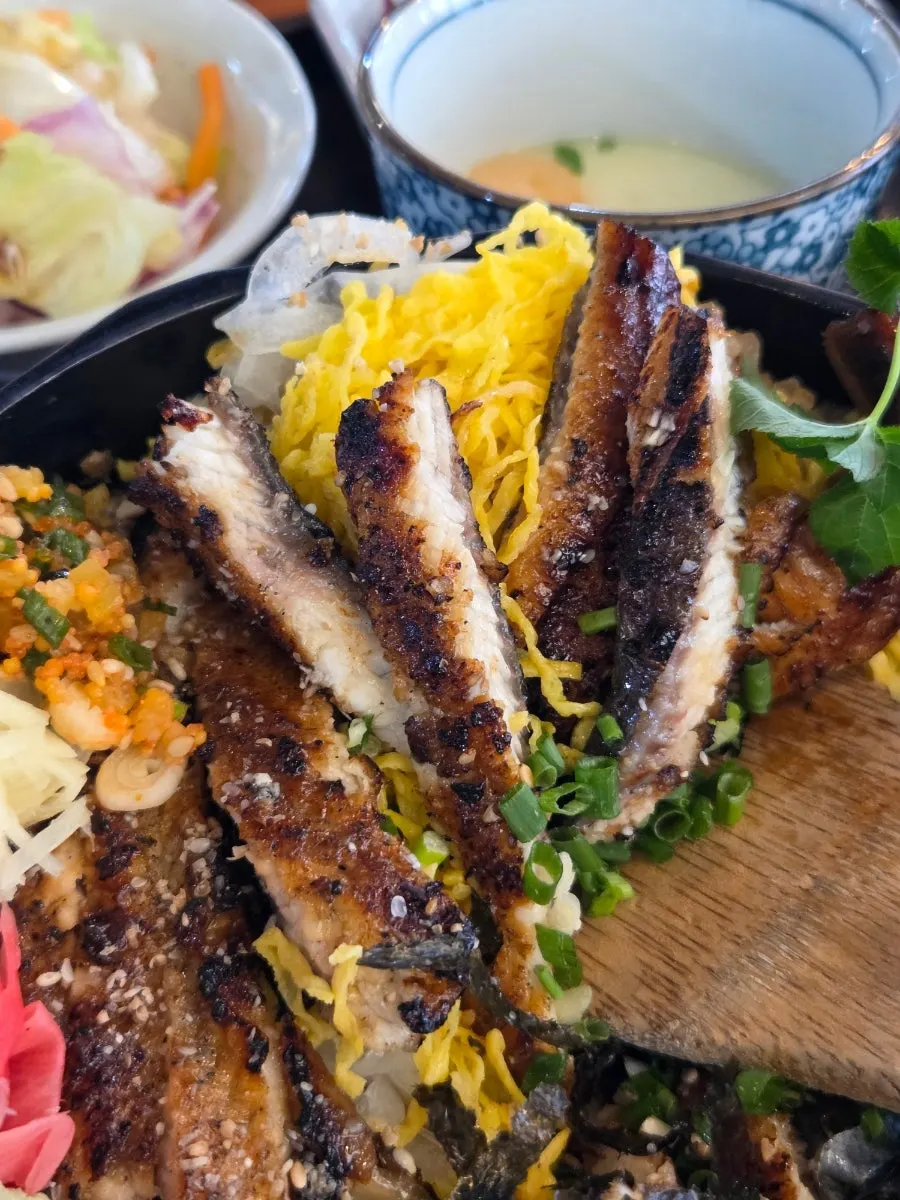Egg strips and onion layered beneath the eel