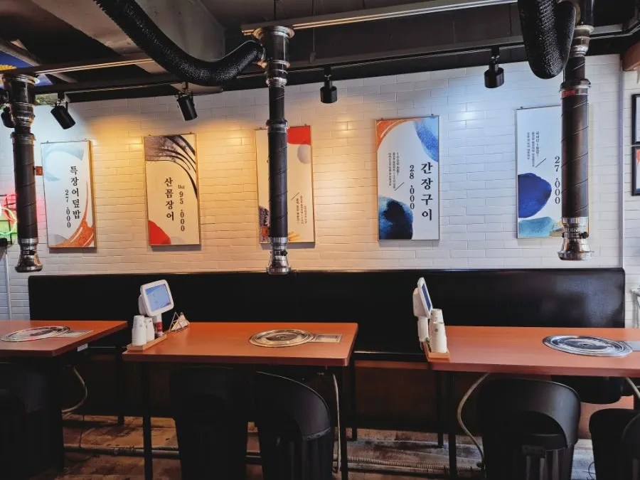 Restaurant seating with grill plates and ventilation systems at each table