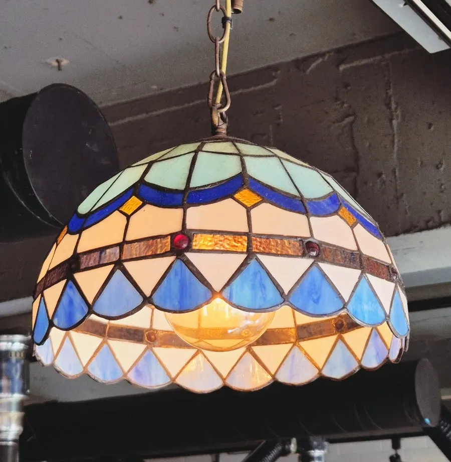 Corner of the restaurant lit by a stained-glass pendant lamp