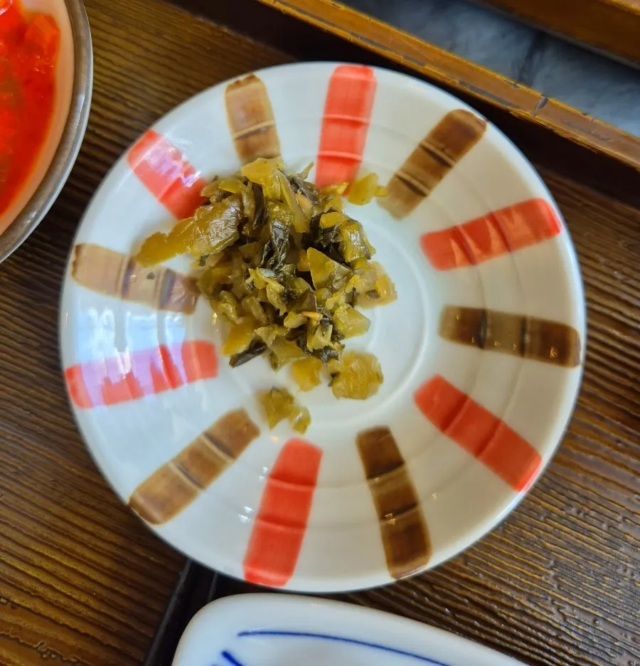Tidy side dishes including cubed radish kimchi and pickles