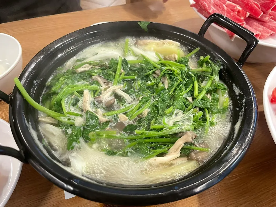 Clear broth with minari and mushrooms cooking